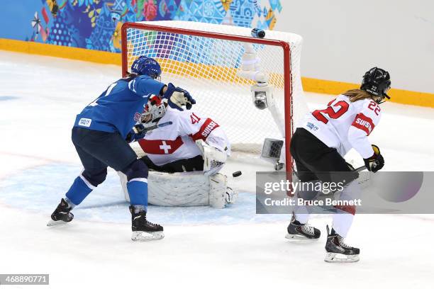 Michelle Karvinen of Finland scores a goal in the second period against Florence Schelling of Switzerland during the Women's Ice Hockey Preliminary...