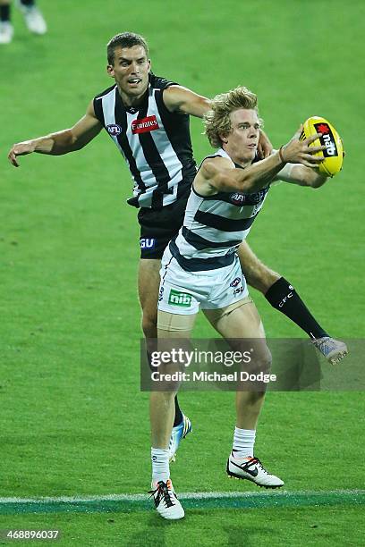 Cameron Guthrie of the Cats marks the ball against Clinton Young during the round one AFL NAB Cup match between the Geelong Cats and the Collingwood...