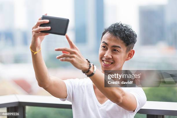 giovane asiatica casual uomo skyline selfie - popolo eurasiatico foto e immagini stock