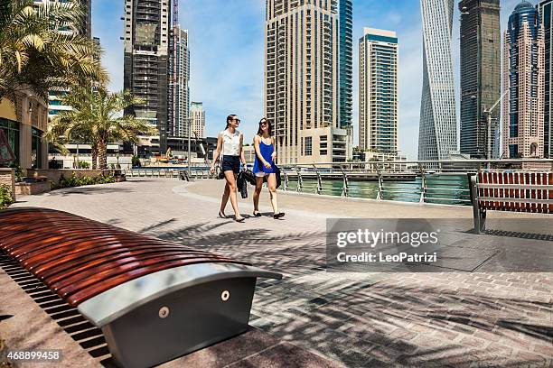 two friends meeting in dubai marina downtown - dubai marina stock pictures, royalty-free photos & images