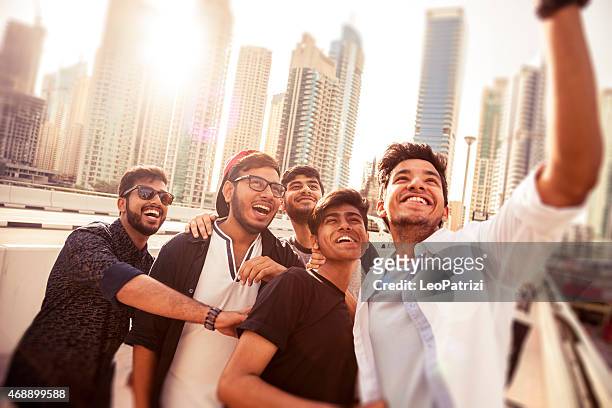 freunde, die ein selfie auf dubai marina bei einem urlaub - arab youth stock-fotos und bilder