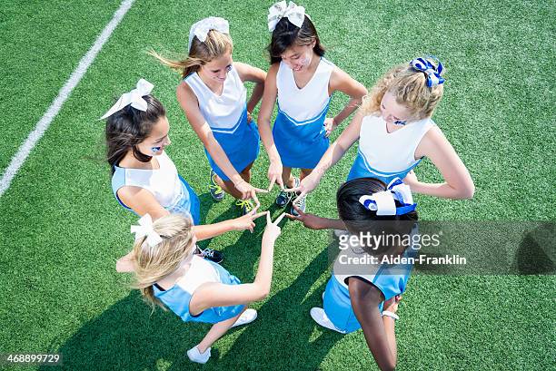 team der high school cheerleader huddled an der seitenlinie - teen cheerleader stock-fotos und bilder