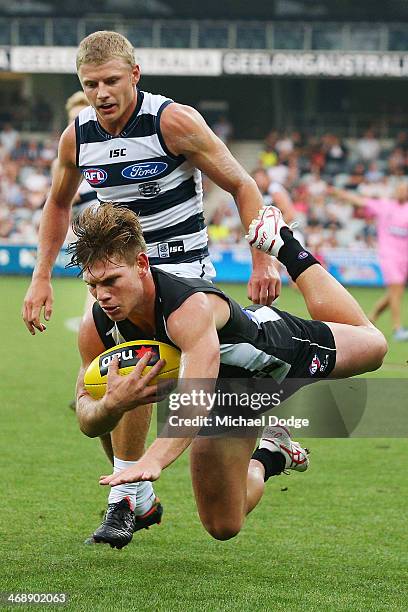 Taylor Adams of the Magpies marks the ball against Taylor Hunt of the Cats during the round one AFL NAB Cup match between the Geelong Cats and the...