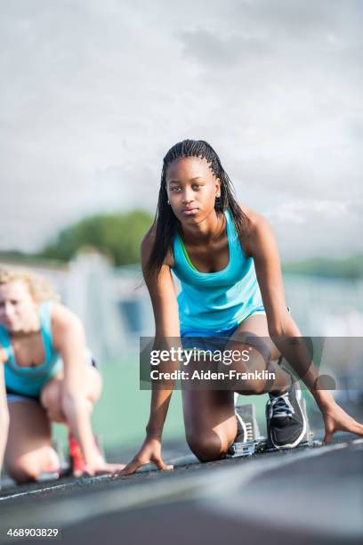 student sportler entschlossen am startblock rennen - girls on train track stock-fotos und bilder