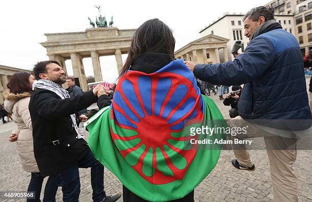 Participant dances with a Romani flag at a pro-Romani demonstration in front of the Brandenburg Gate on International Romani Day on April 8, 2015 in...