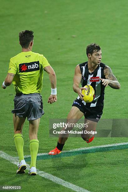 Jamie Elliott of the Magpies runs with the ball during the round one AFL NAB Cup match between the Geelong Cats and the Collingwood Magpies at...