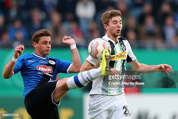 Christoph Kramer of Borussia Moenchengladbach and Tom Schuetz of Arminia Bielelfeld battle for the ball during the DFB Cup Quarter Final match...