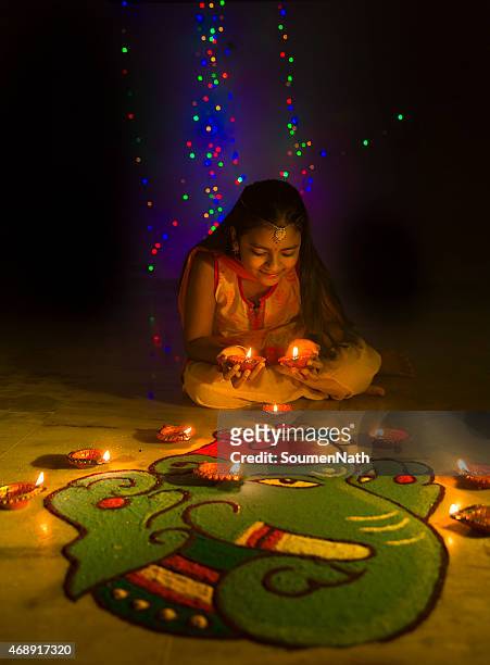 girl making rangoli and decorating with oil lamps for diwali - rangoli stock pictures, royalty-free photos & images