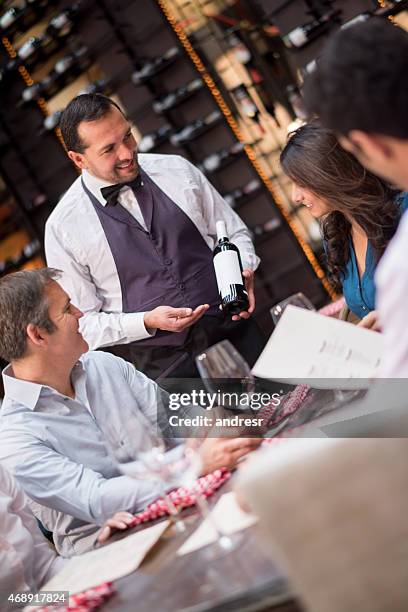 sommelier suggesting a wine to a group of people - sommelier stock pictures, royalty-free photos & images