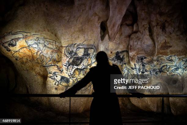Person looks at part of the full-scale reproduction of frescos found at the cave of Pont-D'Arc also known as the Chauvet cave, on April 8, 2015 in...