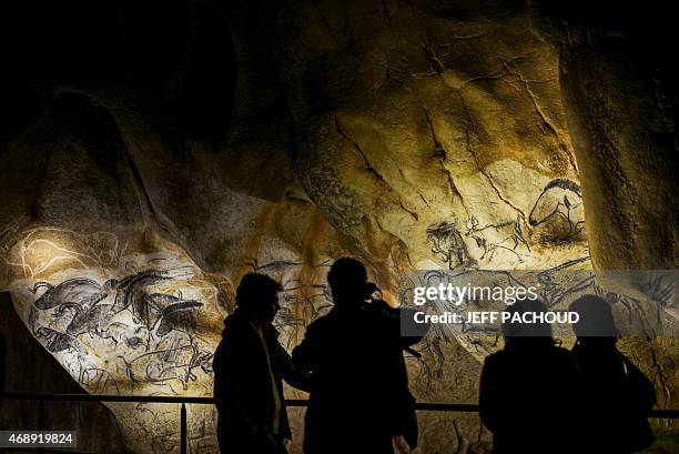 People look at the full-scale reproduction of frescos found at the cave of Pont-D'Arc also known as the Chauvet cave, on April 8, 2015 in Vallon Pont...