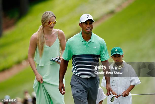 Tiger Woods of the United States walks with his girlfriend Lindsey Vonn and daughter Sam during the Par 3 Contest prior to the start of the 2015...