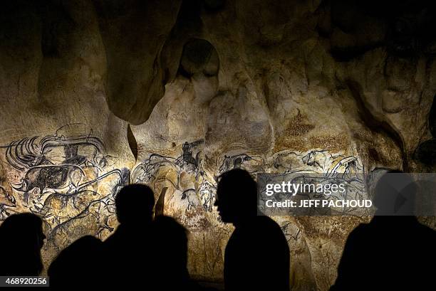 People look at the full-scale reproduction of frescos found at the cave of Pont-D'Arc also known as the Chauvet cave, on April 8, 2015 in Vallon Pont...