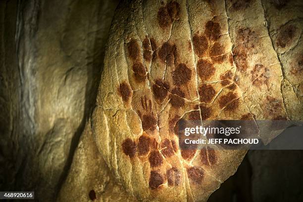 Hand prints make up part of the full-scale reproduction of frescos found at the cave of Pont-D'Arc also known as the Chauvet cave, on April 8, 2015...