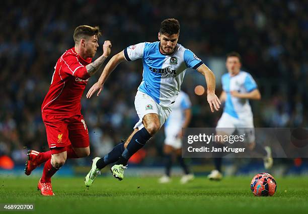 Ben Marshall of Blackburn Rovers and Alberto Moreno of Liverpool chase the ball during the FA Cup Quarter Final Replay match between Blackburn Rovers...