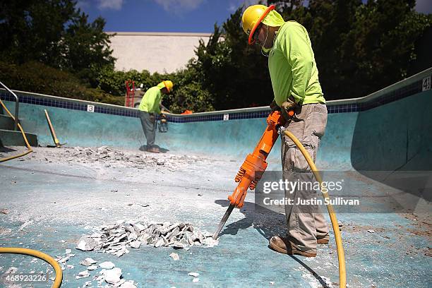 Construction worker Alex Hernandez uses a jackhammer to demolish a swimming pool at an apartment complex on April 8, 2015 in Hayward, California. As...