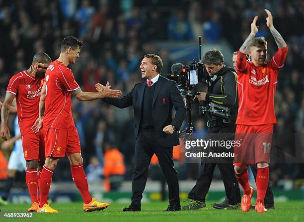 Head coach Brendan Rodgers and player Dejan Lovren of Liverpool celebrate after winning the FA Cup Quarter Final Replay match between Blackburn...