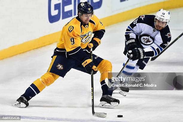 Filip Forsberg of the Nashville Predators skates with the puck as Jim Slater of of the Winnipeg Jets chases during a NHL game at Bridgestone Arena on...