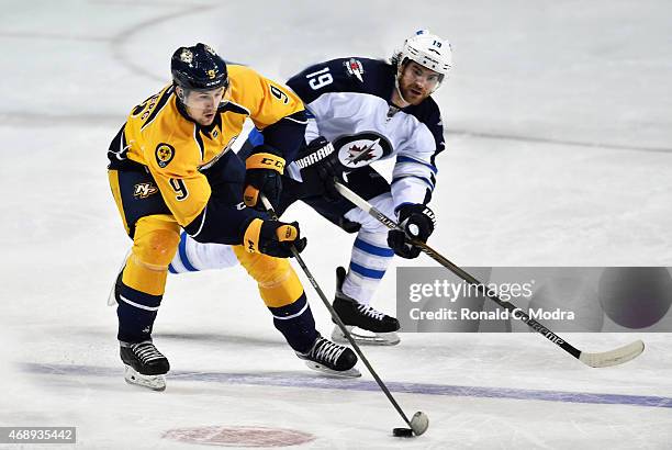 Filip Forsberg of the Nashville Predators skates with the puck as Jim Slater of of the Winnipeg Jets chases during a NHL game at Bridgestone Arena on...