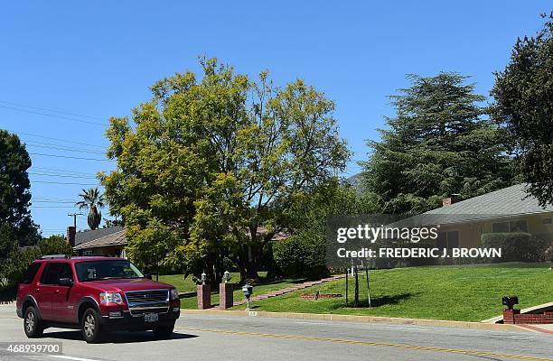 Motorist passes homes with manicured green grass lawns on April 8, 2015 in La Canada Flintridge, California, on the foothills of the San Gabriel...