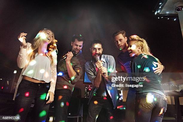 group of friends doing karaoke - karaoke stock pictures, royalty-free photos & images