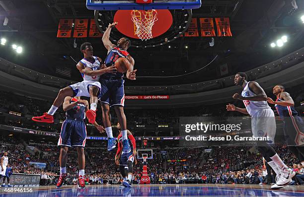 Ish Smith of the Philadelphia 76ers "dishes" the ball to Henry Sims the Washington Wizards at Wells Fargo Center on April 8, 2015 in Philadelphia,...