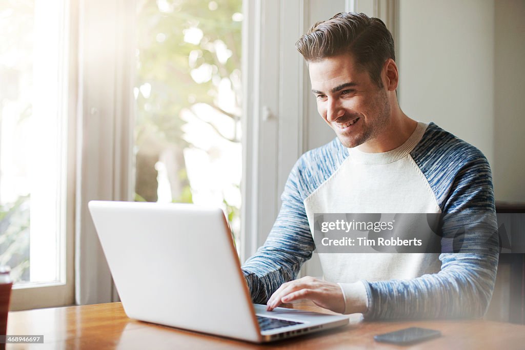 Man using laptop at table.