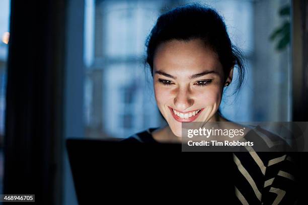 woman lit by screen. - excitement computer stock pictures, royalty-free photos & images