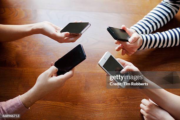 4 friends sharing on smart phones.