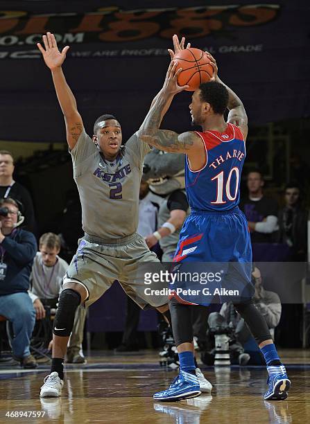 Guard Marcus Foster of the Kansas State Wildcats defends guard Naadir Tharpe of the Kansas Jayhawks during the second half on February 10, 2014 at...
