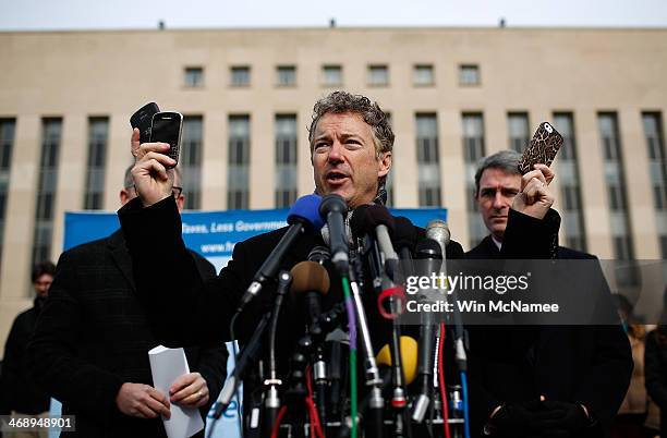 Sen. Rand Paul holds up a group of cell phones in front of U.S. District Court to announce the filing of a class action lawsuit against the...