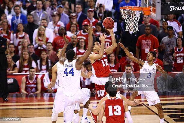 Traevon Jackson of the Wisconsin Badgers drives to the basket against Dakari Johnson of the Kentucky Wildcats during the NCAA Men's Final Four...