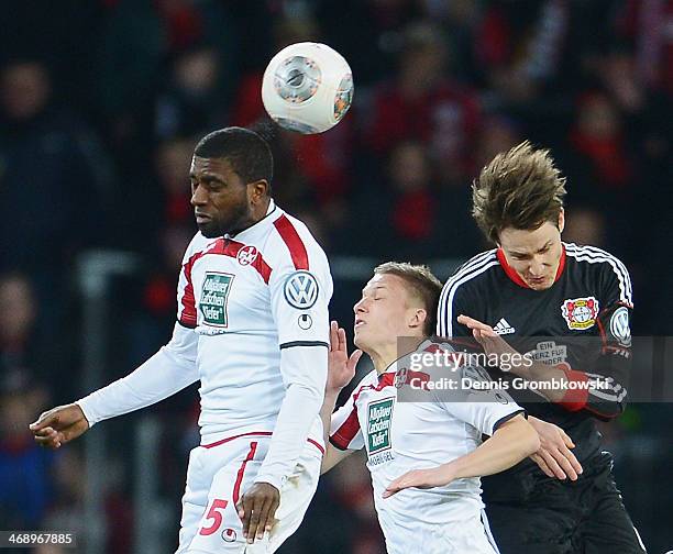 Olivier Occean and Alexander Ring of 1. FC Kaiserslautern challenge Philipp Wollscheid of Bayer Leverkusen during the DFB Cup quarterfinal match...