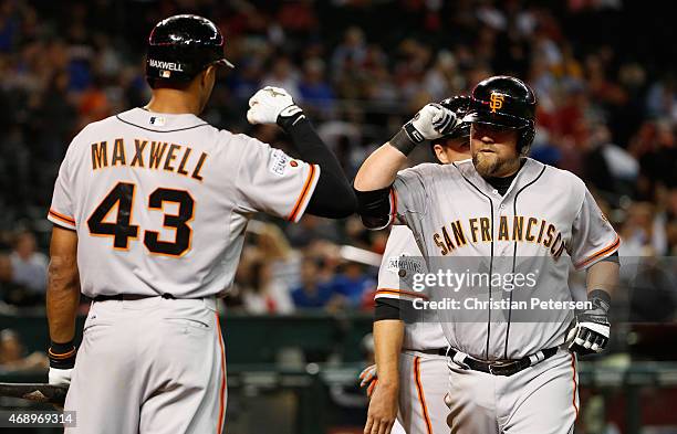 Casey McGehee of the San Francisco Giants high-fives Justin Maxwell at home plate after McGehee hit a two-run home run against the Arizona...