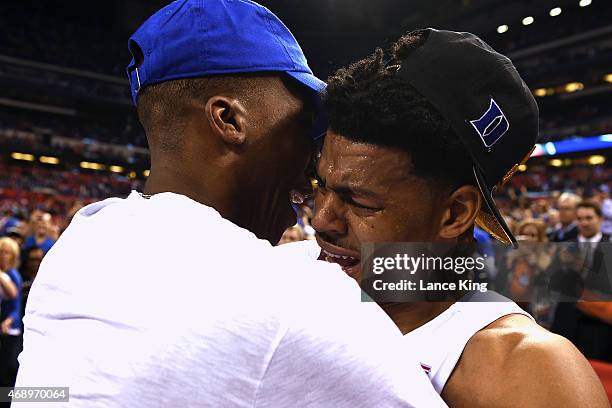 Quinn Cook of the Duke Blue Devils hugs former Duke basketball player Nolan Smith after defeating the Wisconsin Badgers during the NCAA Men's Final...