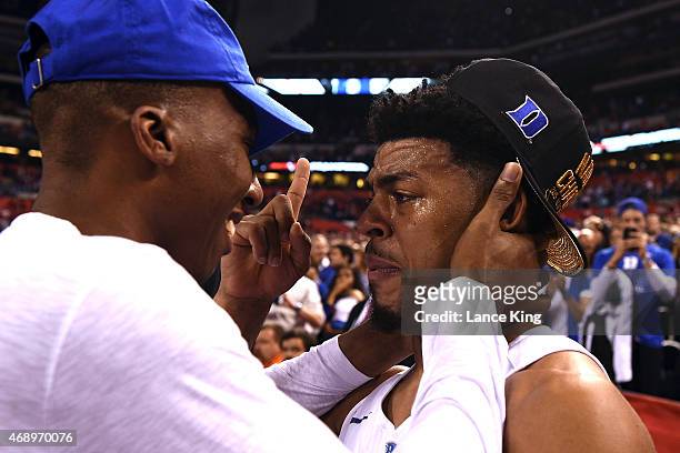 Quinn Cook of the Duke Blue Devils talks with former Duke basketball player Nolan Smith after defeating the Wisconsin Badgers during the NCAA Men's...