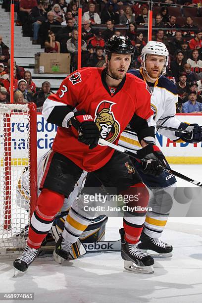 Alexander Sulzer of the Buffalo Sabres defends against Marc Methot of the Ottawa Senators during an NHL game at Canadian Tire Centre on February 6,...