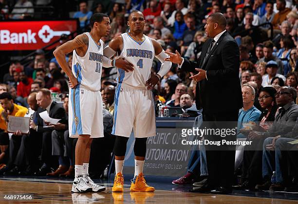 Interim head coach Melvin Hunt of the Denver Nuggets talks with Erick Green and Randy Foye of the Denver Nuggets during a break in the action against...