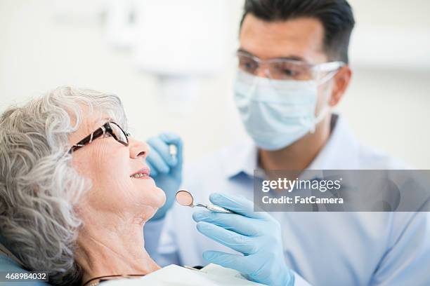 senior female at the dentist - surgical glove stock pictures, royalty-free photos & images