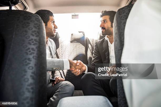 businessmen travelling in car in middle east - middle east friends stock pictures, royalty-free photos & images