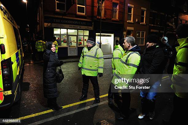 Police and stewards move people on outside the ground as the game is postponed due to building damage caused by the high winds of the Barclays...