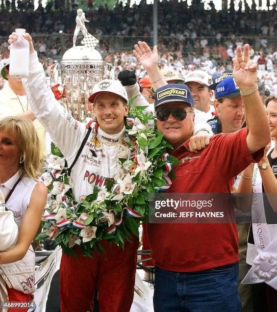 Kenny Brack of Sweden lifts the traditional jug of milk in the winners' circle with car owner and four-time winner of the Indianapolis 500 A.J. Foyt...