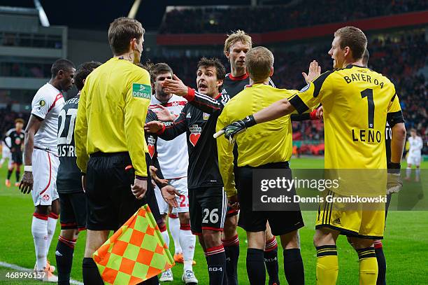 Bayer Leverkusen players aruge with referee Tobias Welz during the DFB Cup quarterfinal match between Bayer Leverkusen and 1. FC Kaiserslautern at...