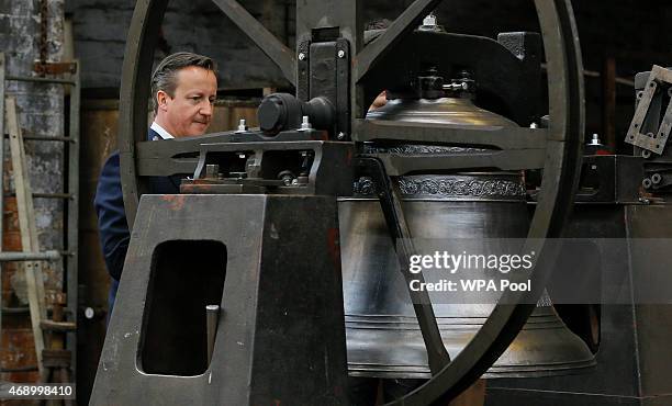 Britain's Prime Minister David Cameron looks at a bell during a visit to John Taylor Bell Foundry on April 9, 2015 in Loughborough, England. Britain...