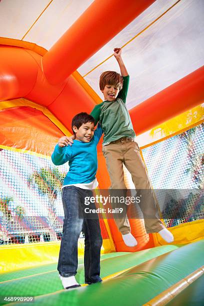 boys in bounce house - inflatable playground stock pictures, royalty-free photos & images