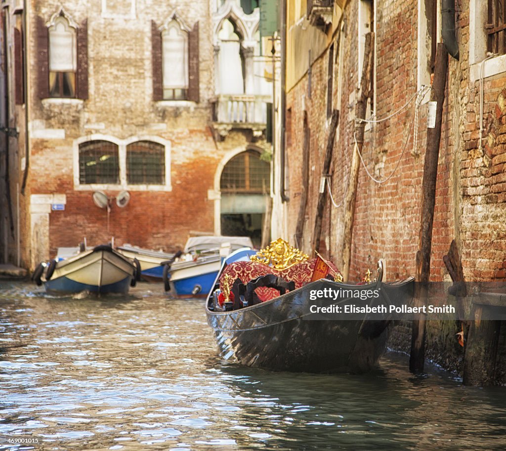 Gondola and boats in small canal, Venice, Italy