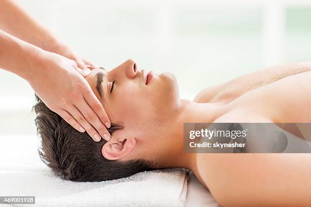 uomo riceve massaggio alla testa alla spa. - head massage foto e immagini stock