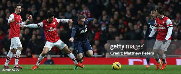 Wayne Rooney of Manchester United in action with Mesut Oezil, Mikel Arteta and Tomas Rosicky of Arsenal during the Barclays Premier League match...