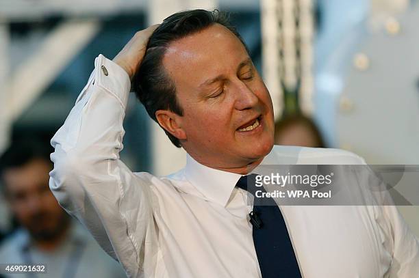 Britain's Prime Minister David Cameron touches his hair as he speaks during a question and answer session at the National Grid Training Centre on...