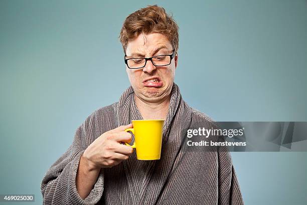 nerdy guy drinking bad coffee - bot stockfoto's en -beelden